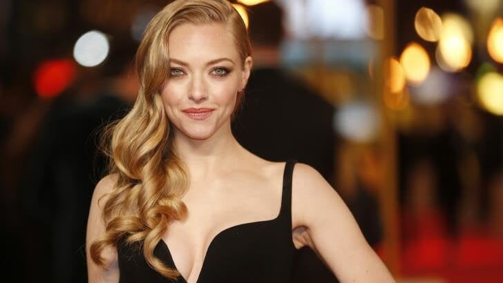 Amanda wearing a black dress at a red carpet event.