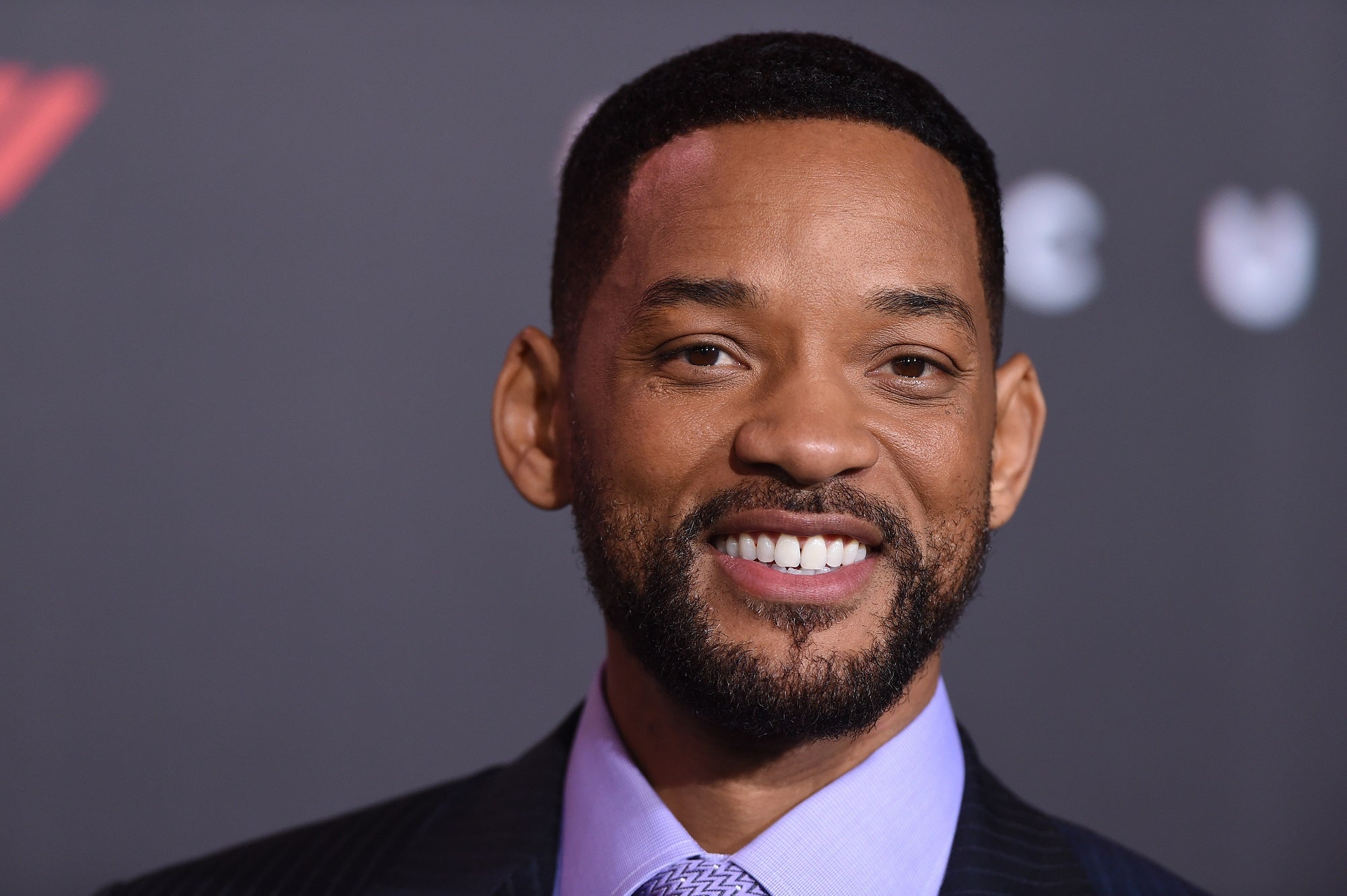 A headshot of Will Smith, smiling and looking at the camera.
