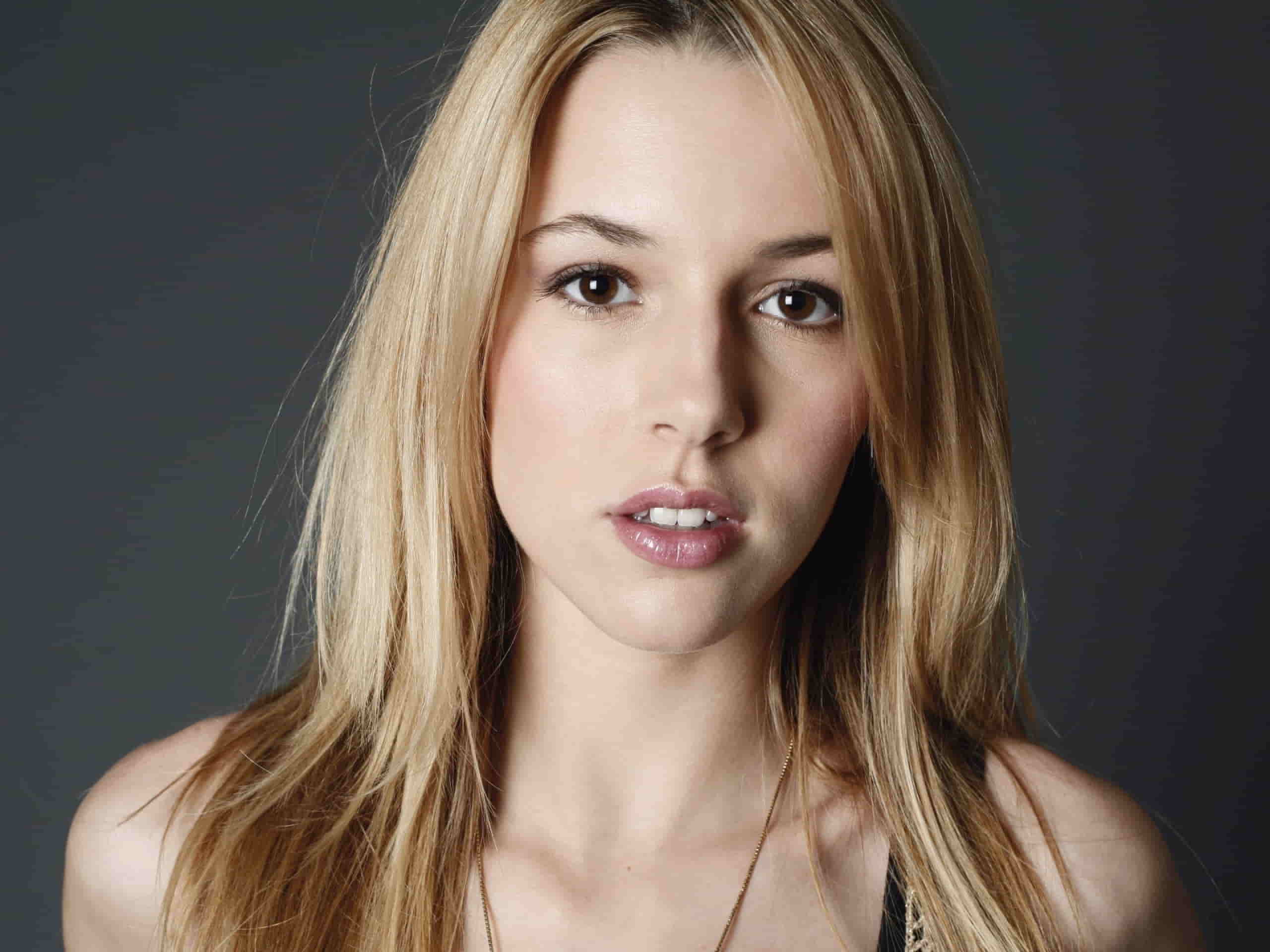 Alona Tal in open hair, posing in front of a dark grey background.