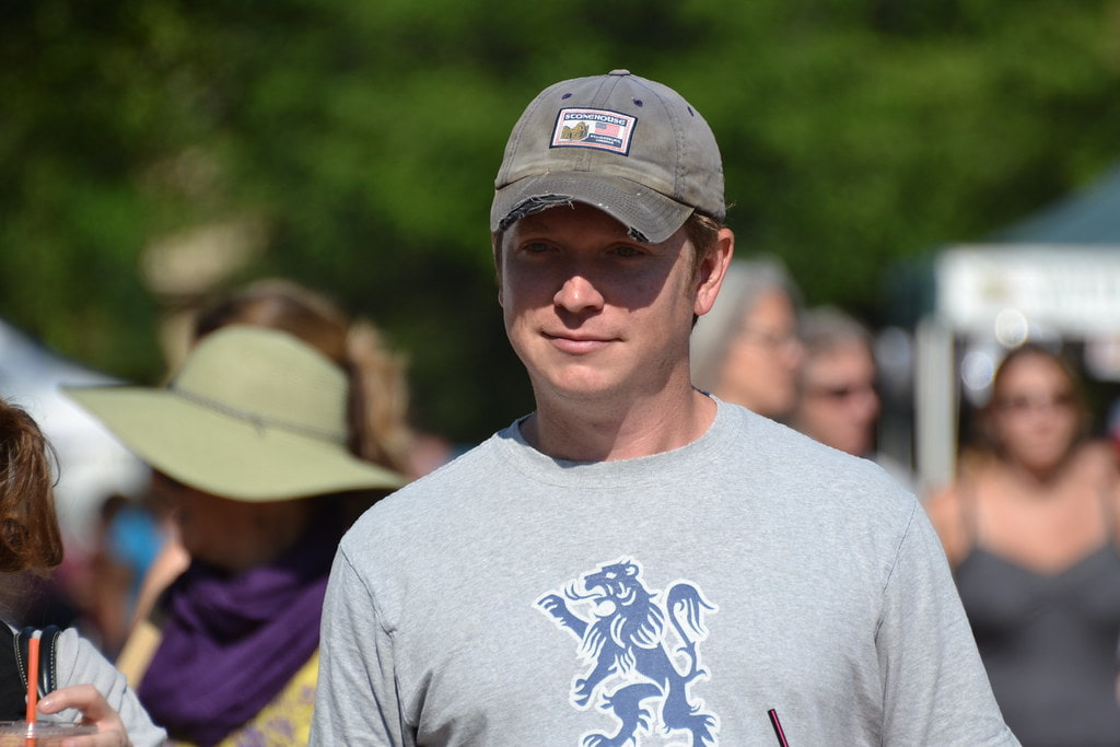 Bobby Flay in a grey t-shirt and a dark grey colored cap