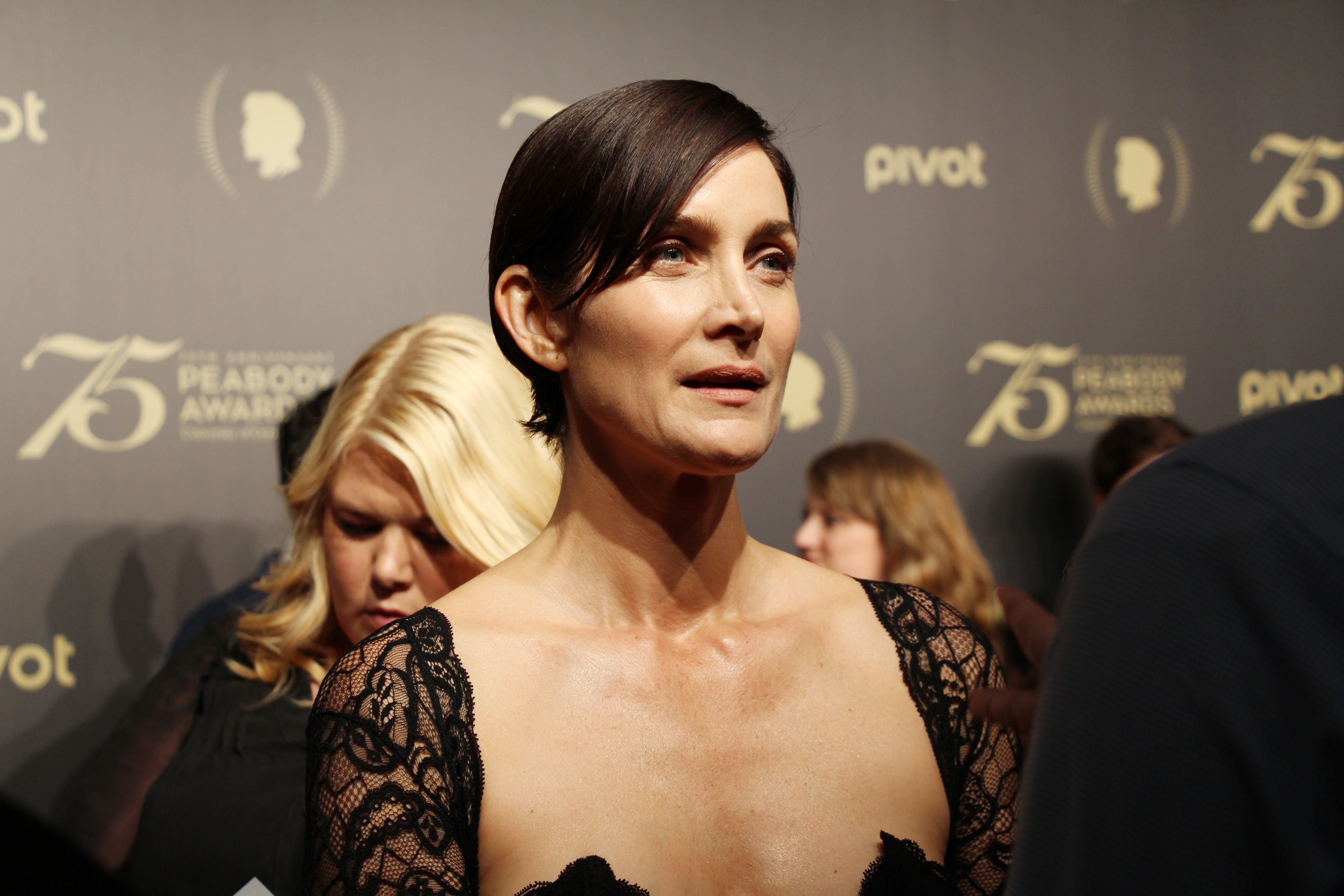 Carrie Anne Moss in a black dress at the premier of her show Jessica Jones.