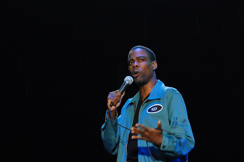 Chris Rock holding a microphone and addressing the crowd.