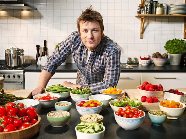 Jamie Oliver leaning on his cooking counter