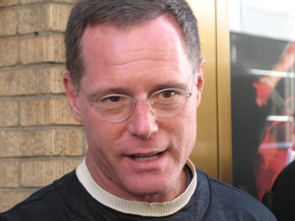 Jason Beghe wearing glasses looking directly at the camera