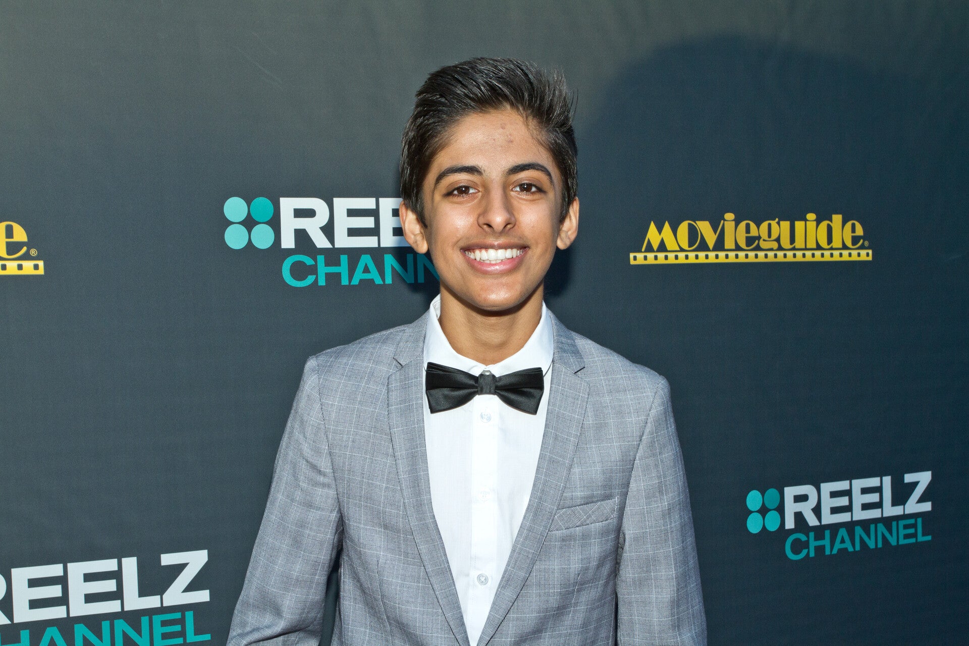 Karan Brar is smiling for the camera at an event.