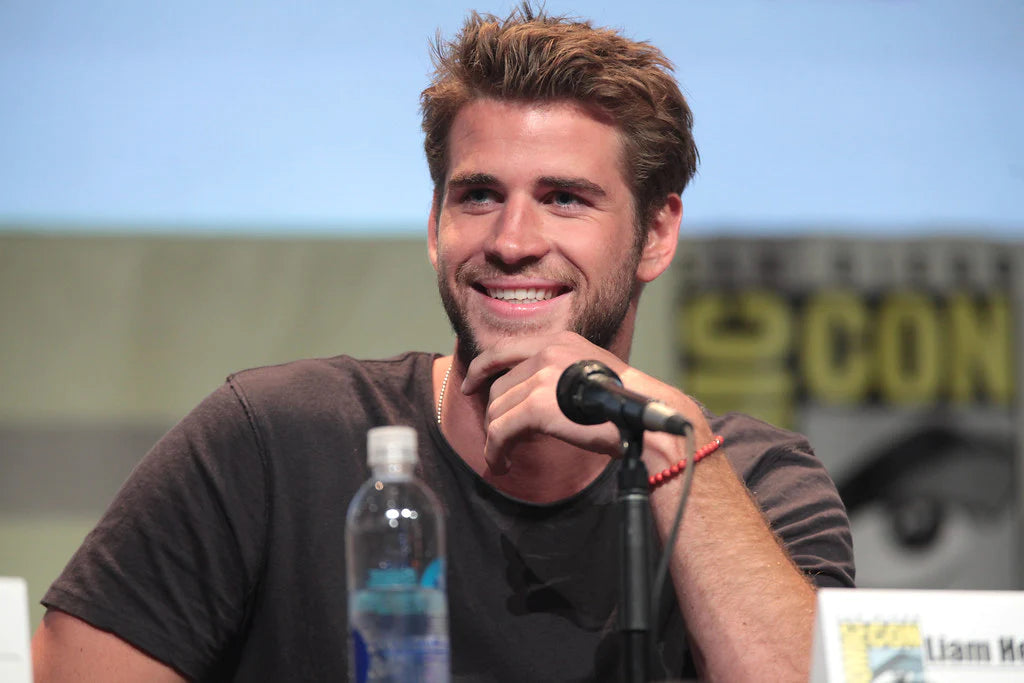 Liam Hemsworth at a comicon smiling at the crowd