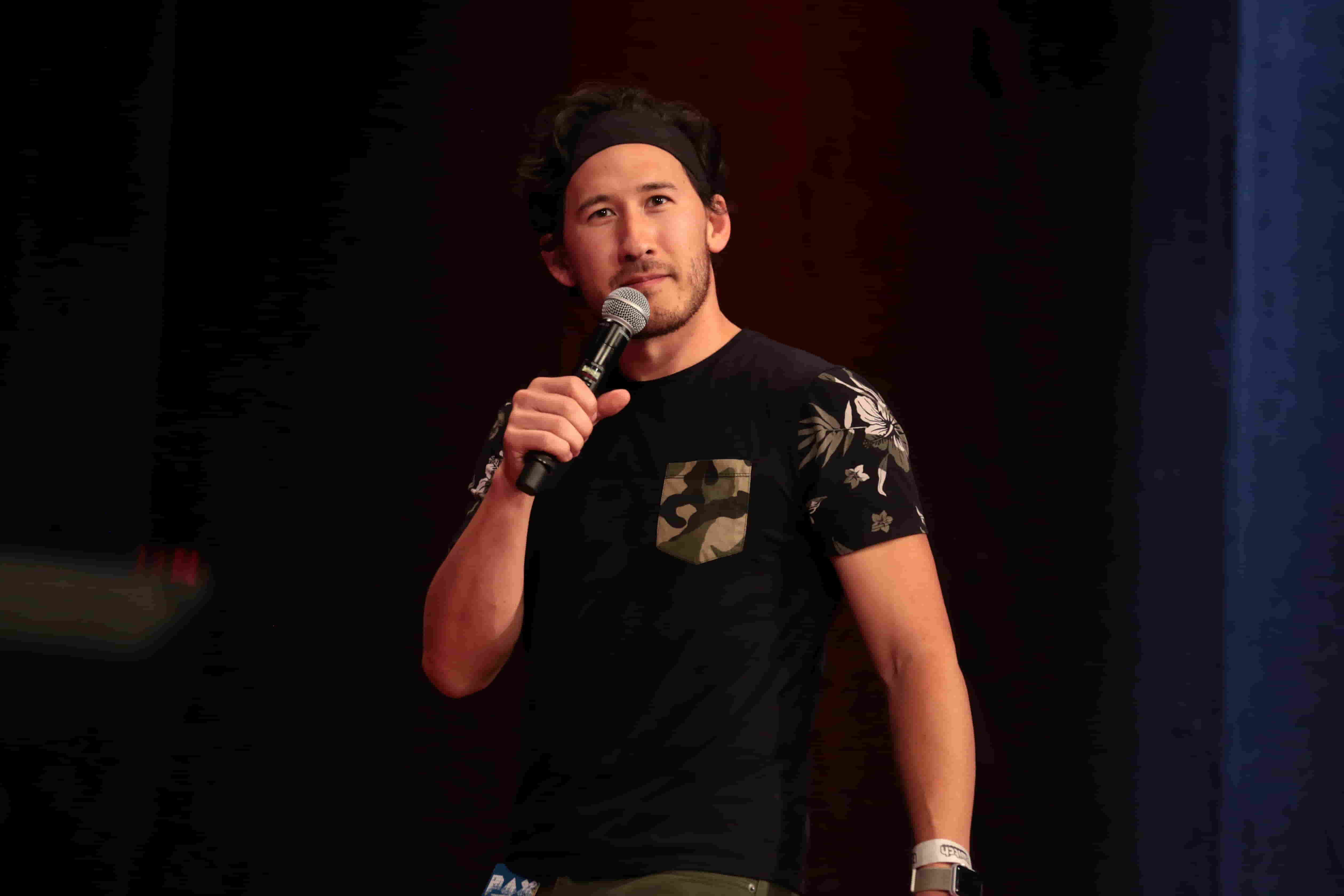 Markiplier Mark in a black t-shirt holding a mic in his right hand