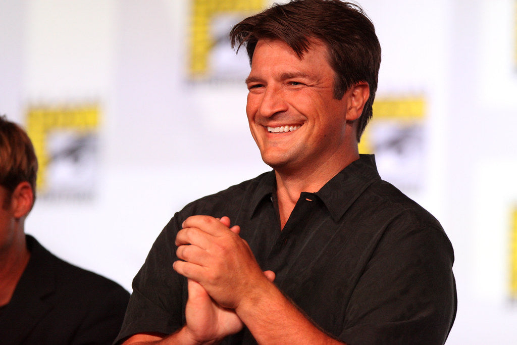 Nathan Fillion at comicon event, looking at the audience and smiling