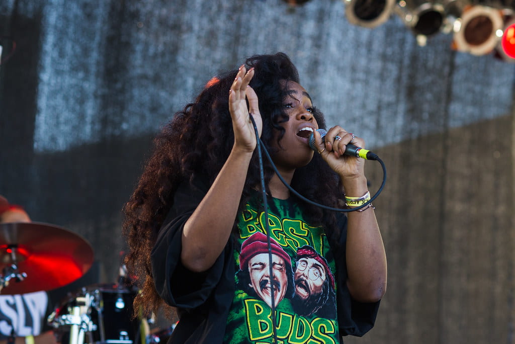 Sza is singing, holding a microphone 